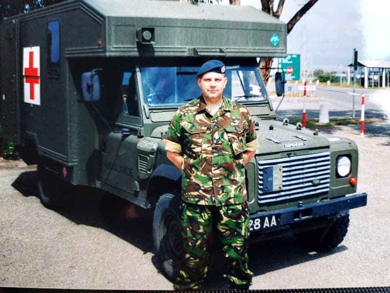 Steve Grocutt in RAF uniform beside a military field ambulance